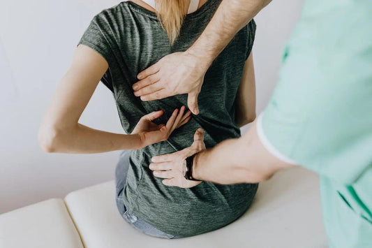 A woman touching her upper back