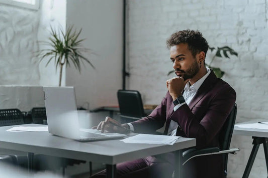 A man in a burgundy suit focused at work