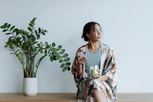 a pensive woman drinking a green shake
