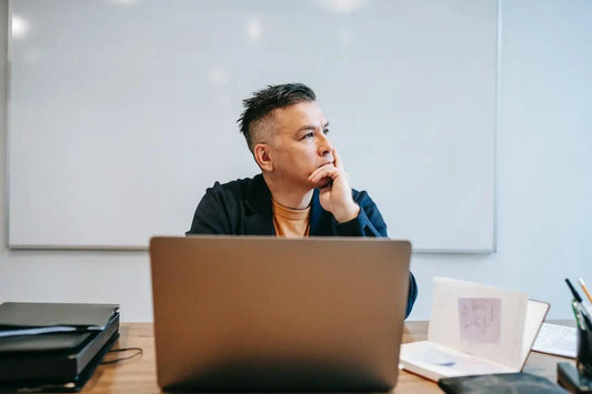 A pensive man on his computer looking away