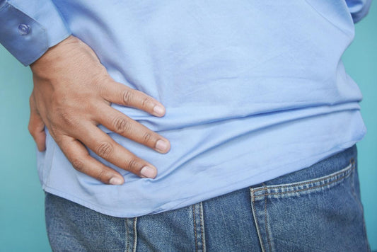 a man with back pain grabbing his hip