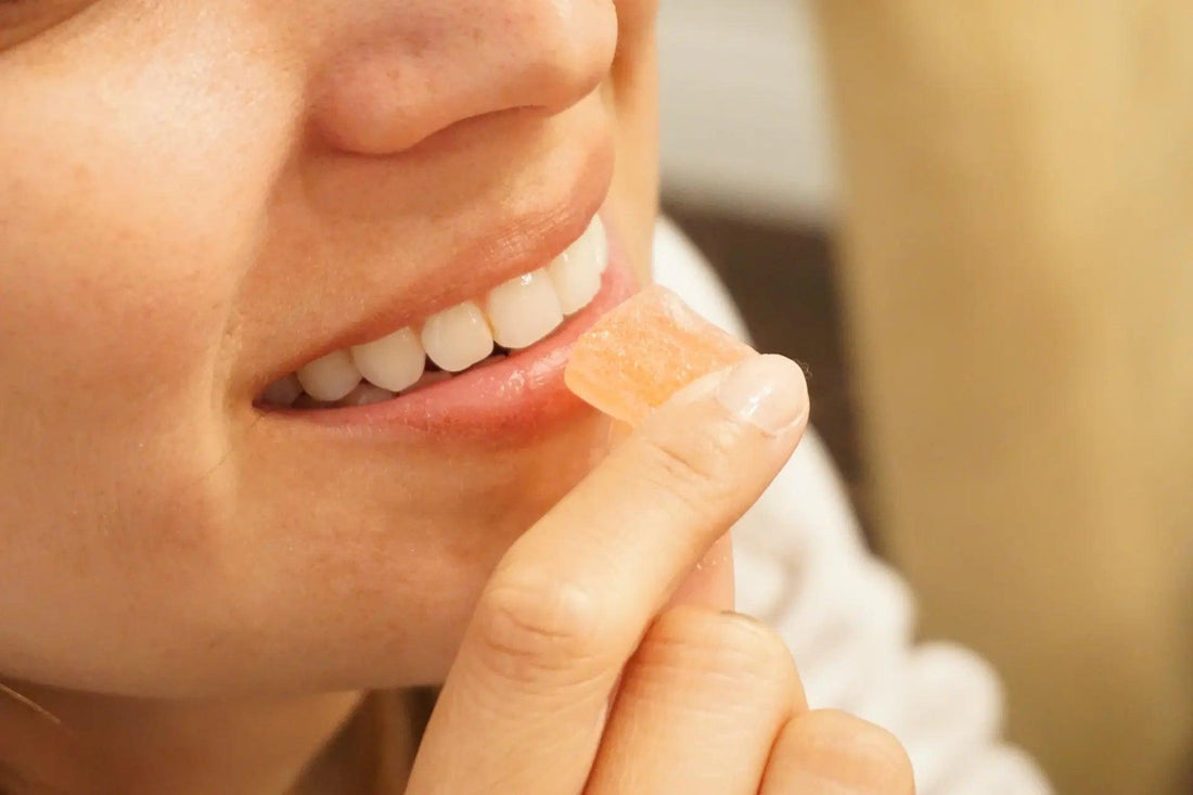 a happy woman eating a CBD gummy