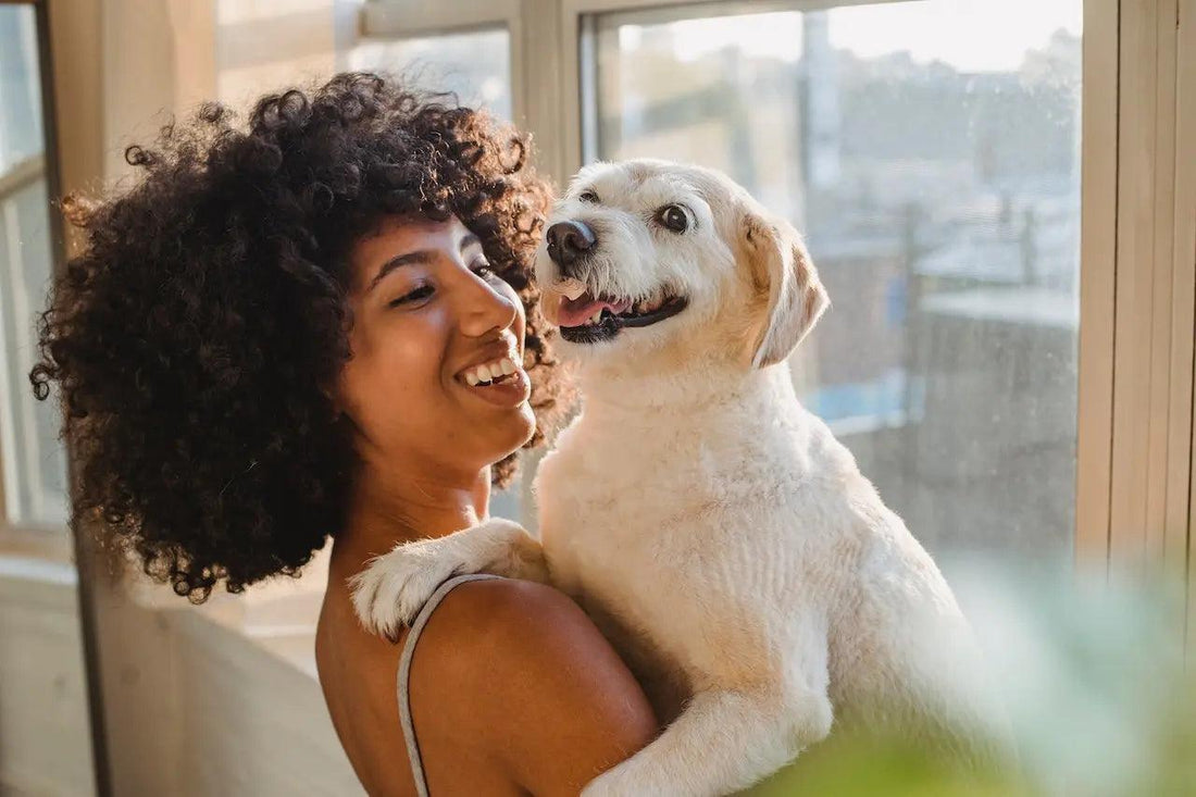 A cheerful dog smiling next to a woman