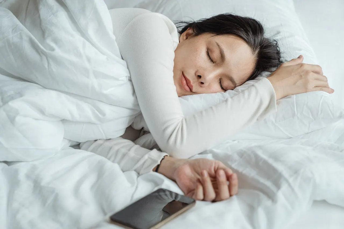 a woman sleeping near her cellphone
